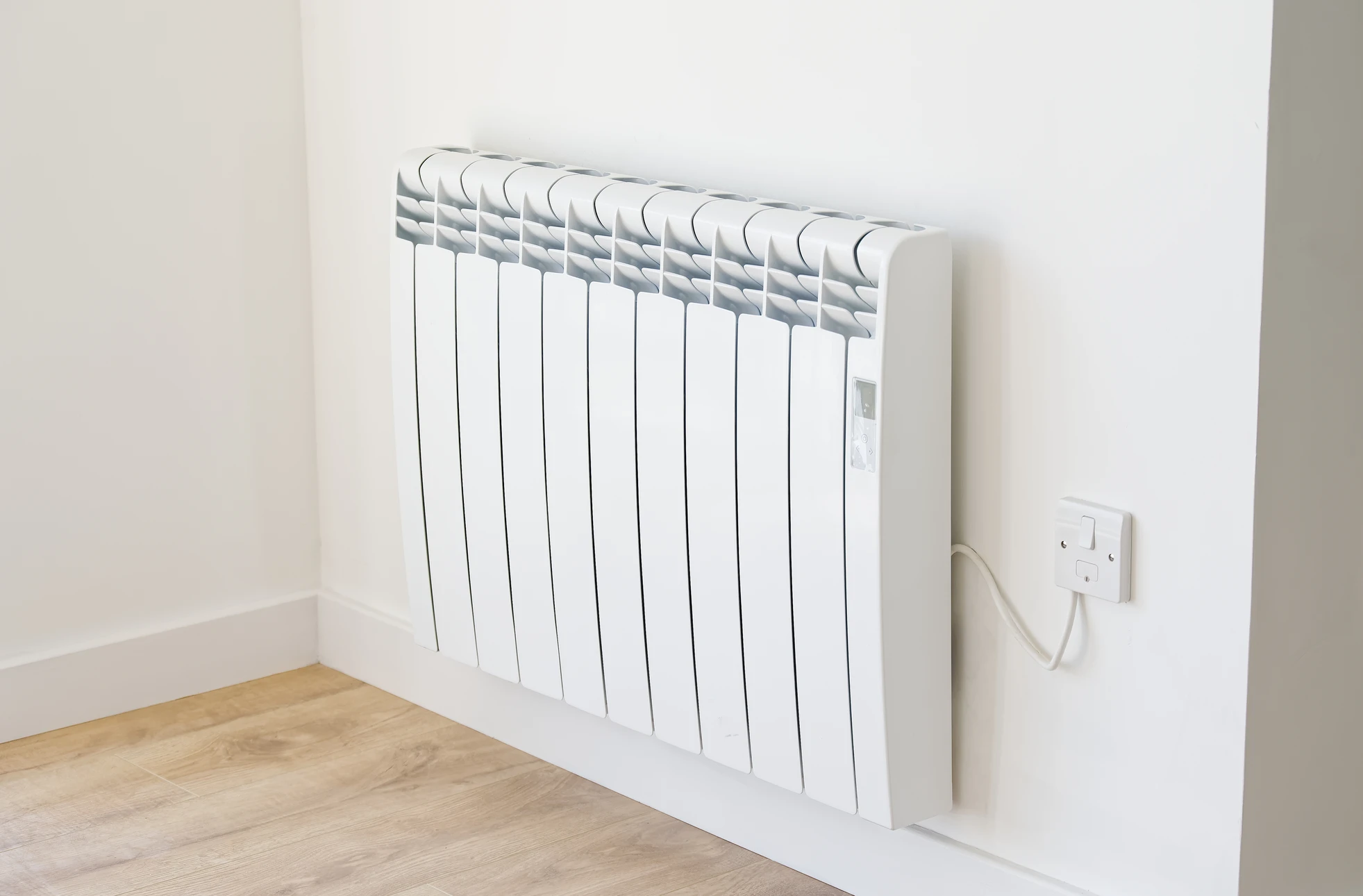 Intérieur résidentiel moderne avec radiateur électrique blanc à inertie installé contre mur blanc