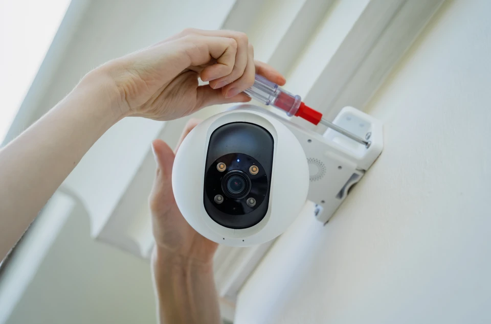Un technicien installe une caméra CCTV sur la façade d'un immeuble d'habitation