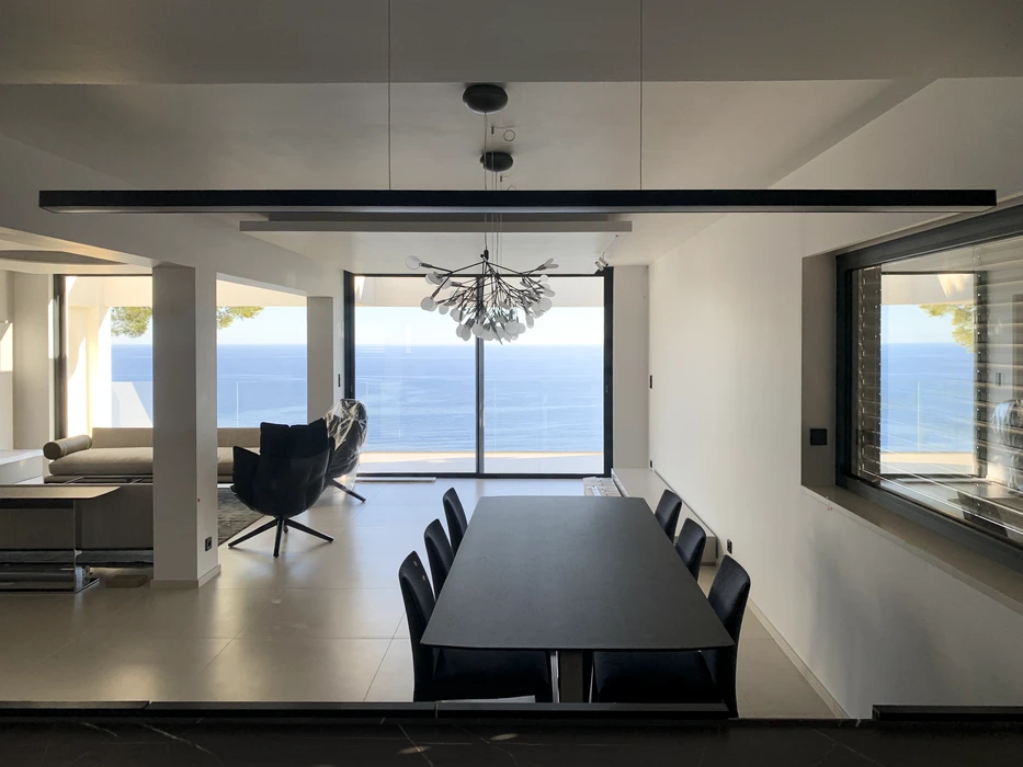 Un technicien intervient sur un tableau électrique domestique ouvert, utilisant un tournevis à manche isolé pour ajuster les disjoncteurs modulaires