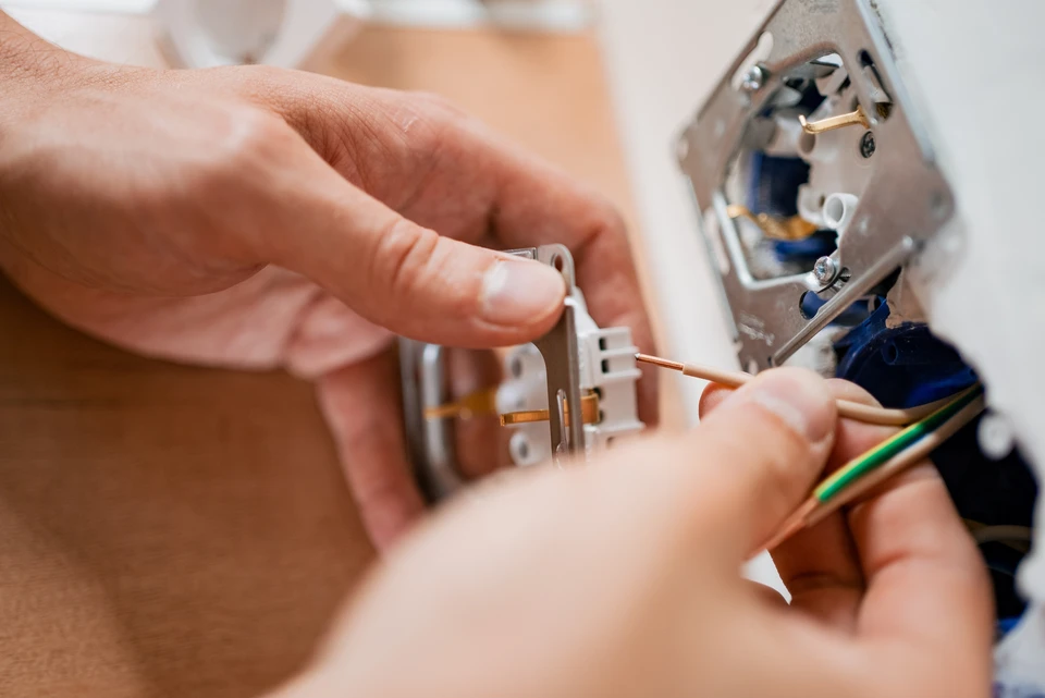 Électricien professionnel travaillant sur un tableau électrique dans un bâtiment en construction