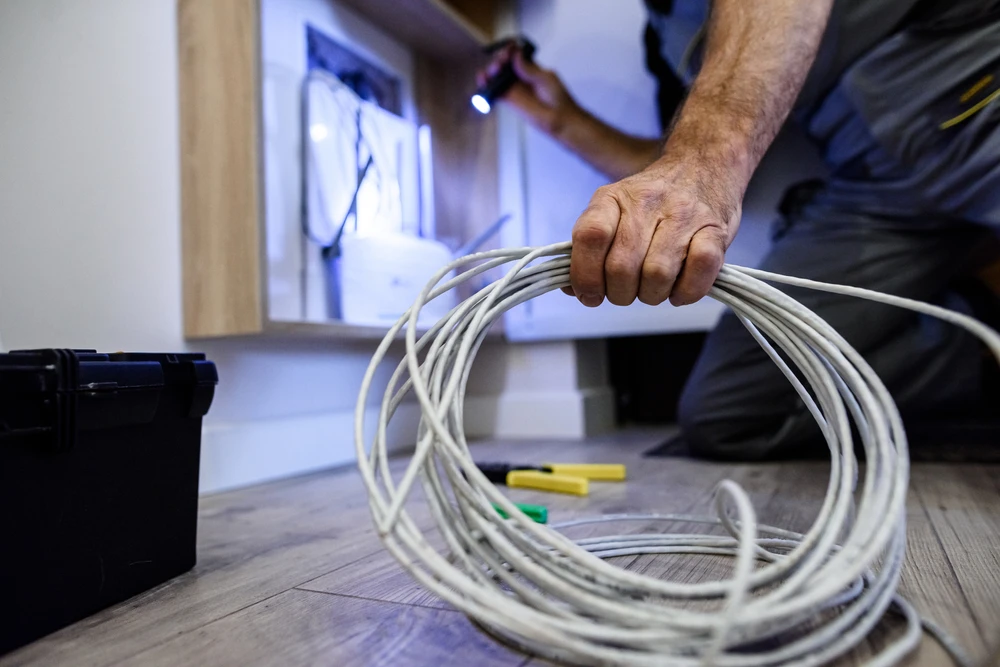 Salle de serveurs avec technicien en chemise blanche travaillant sur équipements informatiques