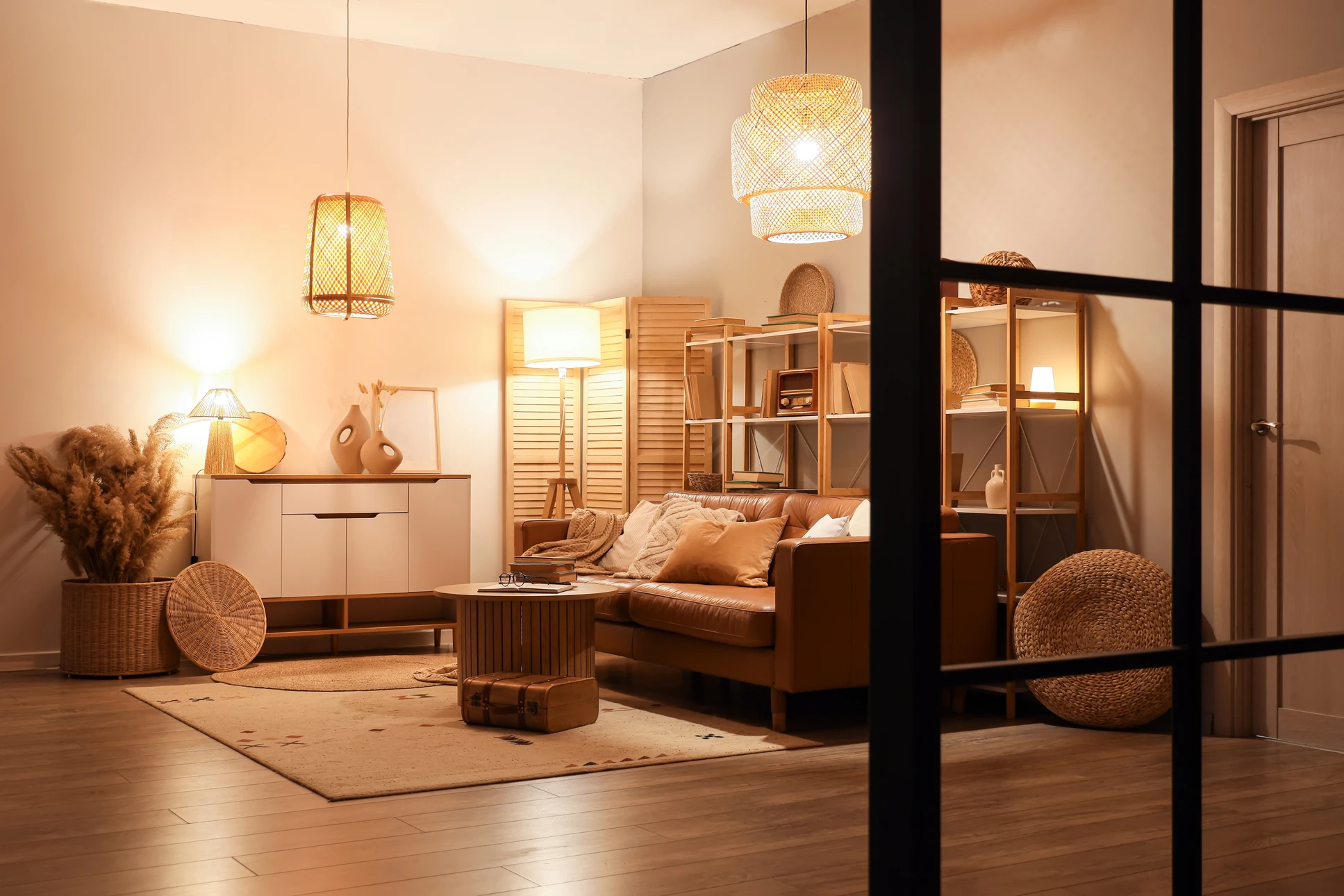 Intérieur résidentiel moderne et lumineux montrant un électricien professionnel installant ou ajustant un luminaire mural au plafond d'une pièce blanche, en tenue de travail avec outils, dans un contexte de rénovation électrique. Jeu de lumière mettant en valeur le soin apporté à l'installation des éclairages modernes et la qualité du rendu final.