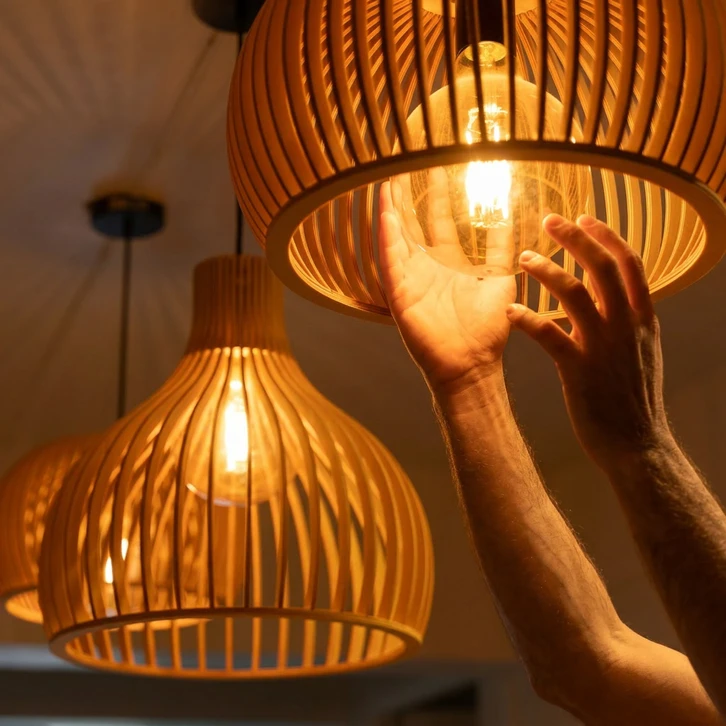 Artisan électricien installant un luminaire suspendu dans cuisine moderne en rénovation