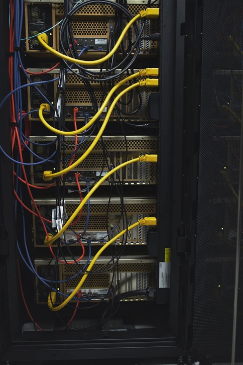 Gros plan sur des câbles Ethernet bleus disposés en parallèle dans un environnement de centre de données ou d'infrastructure réseau professionnel