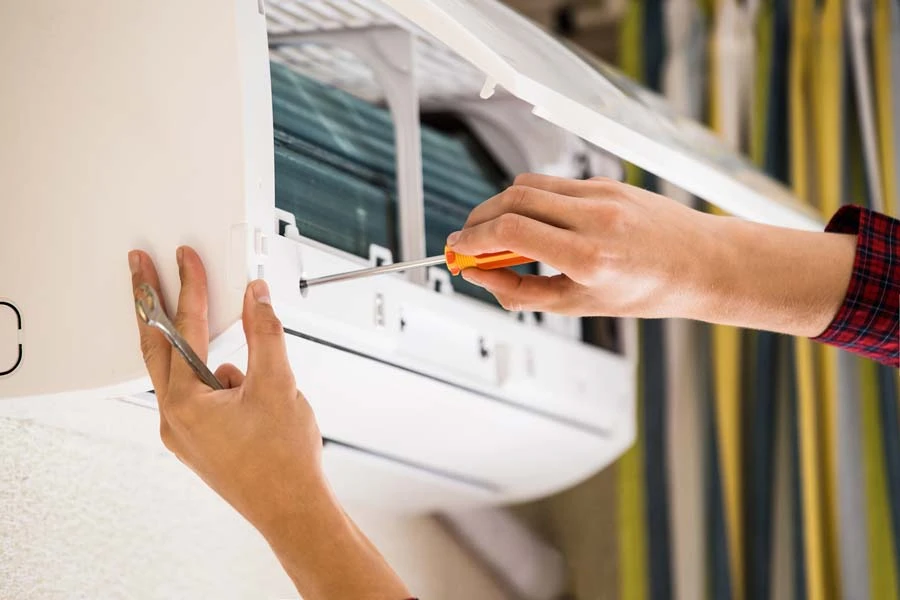 Master installe le boîtier métallique du climatiseur à distance à l'aide d'un tournevis automatique